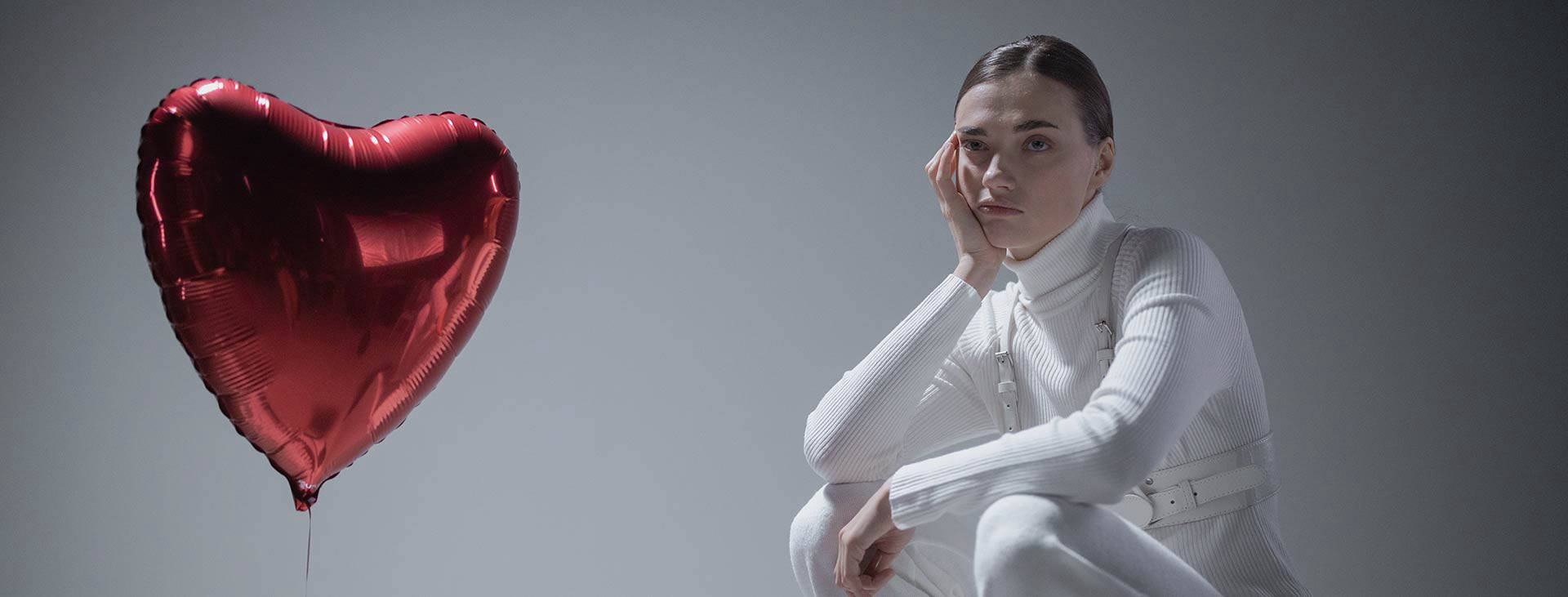 Traurige Frau mit Herzluftballon